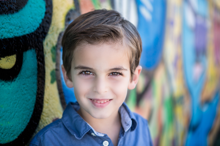 Child beside a colorful wall