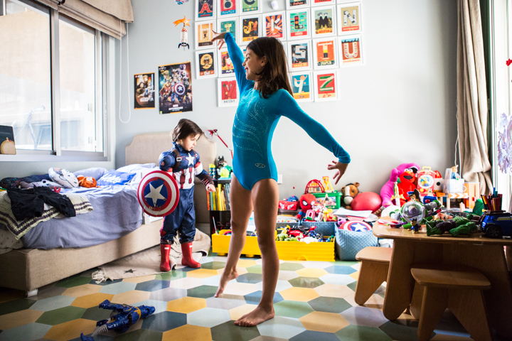 A woman and child play among colorful toys in a bright room.