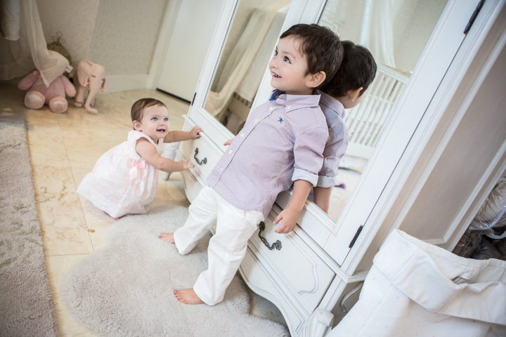 Two young children play beside a white doorway.