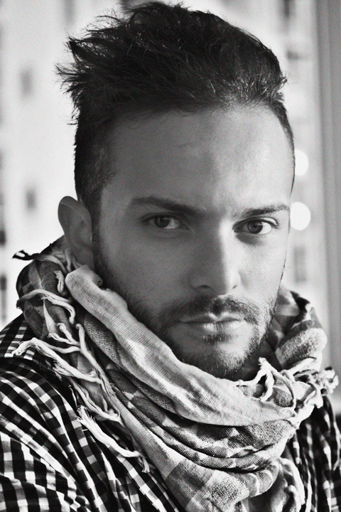A close portrait of a man wearing a patterned scarf.