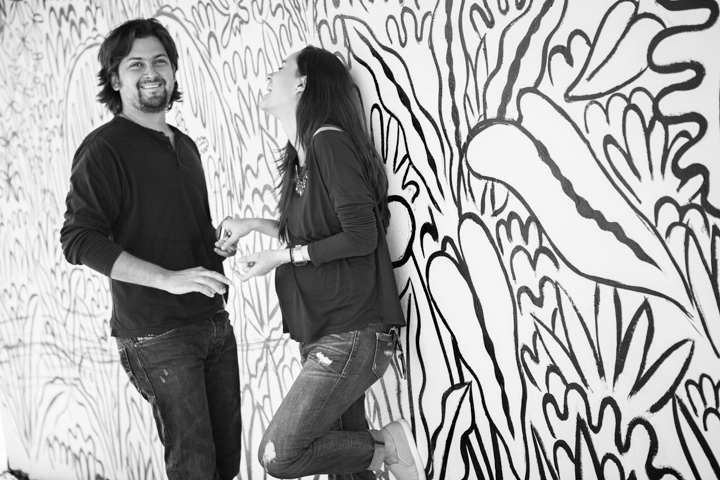 Two people sharing a moment against an illustrated wall