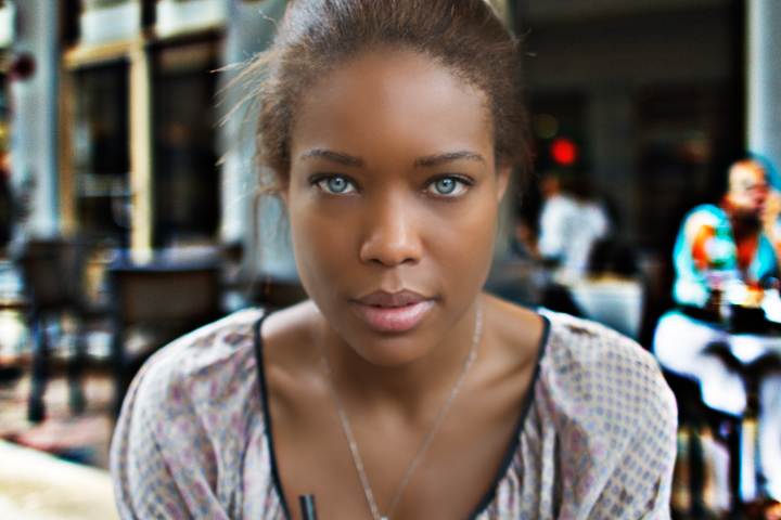 A close portrait of a woman seated at an outdoor table.