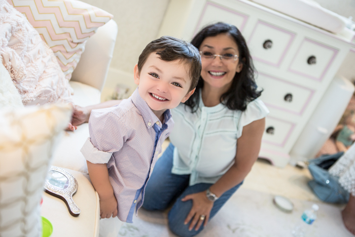 A woman and child smile together in a bright room.