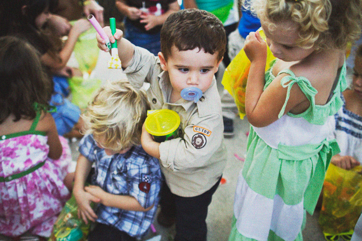 Several children play with colorful toys together outdoors.
