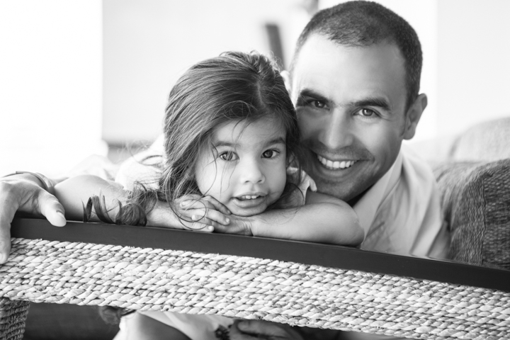 A man and child lean close together in a black-and-white portrait.