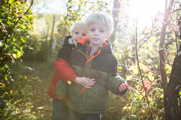 Twin boys among sunlit trees