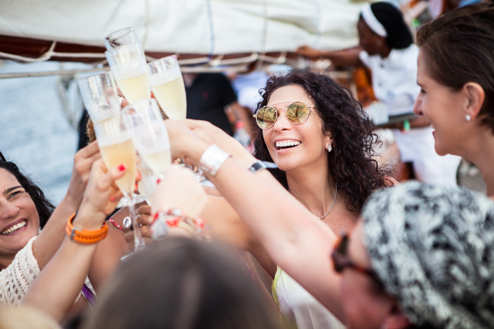 A group raises glasses together in a cheerful outdoor toast.