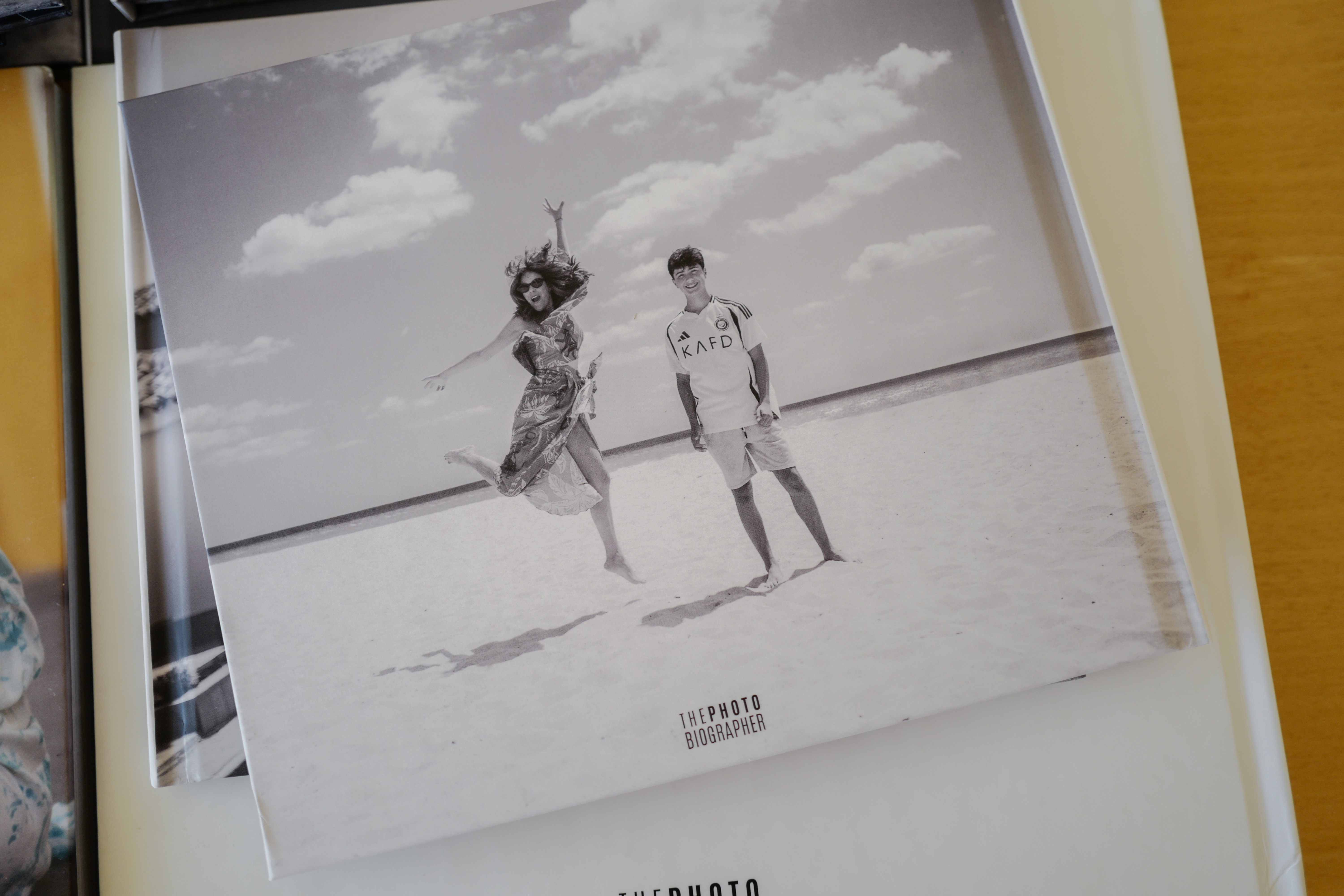 A PHOTObiography book cover shows a black-and-white photograph of two people at the beach.