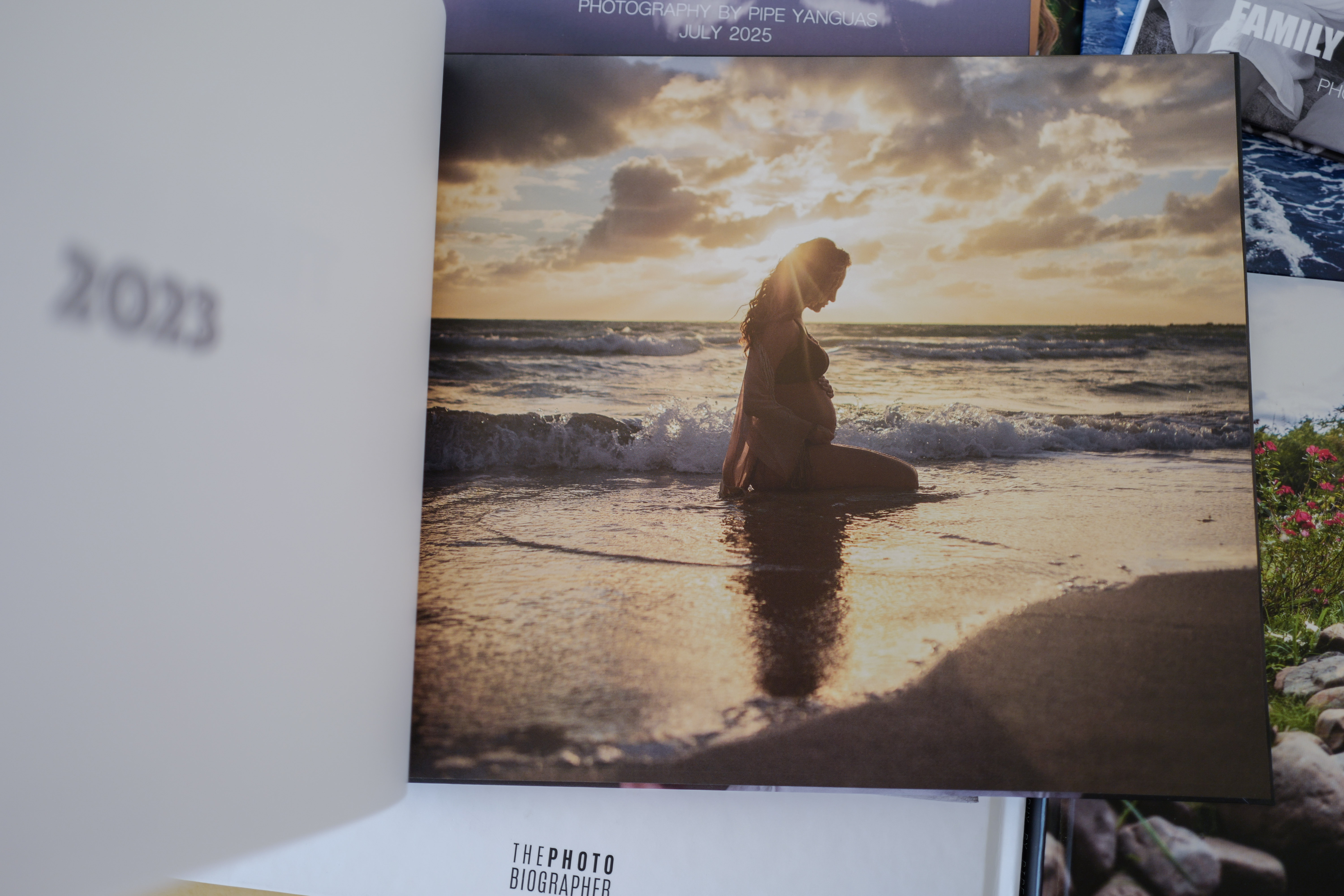 A PHOTObiography book with a sunset portrait is displayed in front of another book.