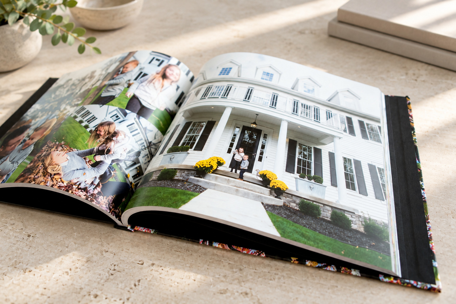 An open PHOTObiography book with family photographs rests on a pale stone table.